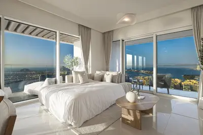 a bedroom with a large white bed and large windows at Luxe 4BR with Panoramic Views l Marina & Burj in Dubai