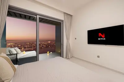 a bedroom with a large window with a tv on the wall at Luxe 4BR with Panoramic Views l Marina & Burj in Dubai