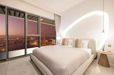 a bedroom with a white bed and large windows at Luxe 4BR with Panoramic Views l Marina & Burj in Dubai