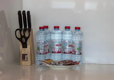 a group of bottles of water next to a pair of scissors at Nice 2 Bedroom Apartment! 5 Minute walk to Dubai Mall! Burj Khalifa View! in Dubai
