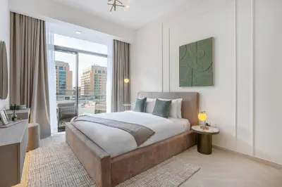 a bedroom with a large bed and a large window at Stylish 1BR Retreat in JVC Modern & Cozy Stay in Dubai