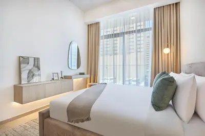 a bedroom with a large bed and a large window at Stylish 1BR Retreat in JVC Modern & Cozy Stay in Dubai