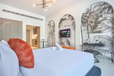 a bedroom with a white bed and a wall with arches at Stylish Studio Retreat Modern Stay in JVC in Dubai