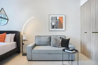 a living room with a couch and a bed at Stylish Studio Retreat Modern Stay in JVC in Dubai