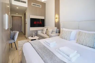 a bedroom with a large white bed and a couch at Modern Meydan Studio Burj View Downtown in Dubai