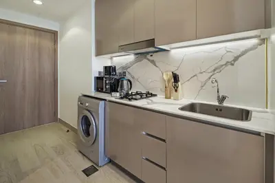 a kitchen with a sink and a washing machine at Luxury Meydan Studio Near Dubai Mall & Downtown in Dubai