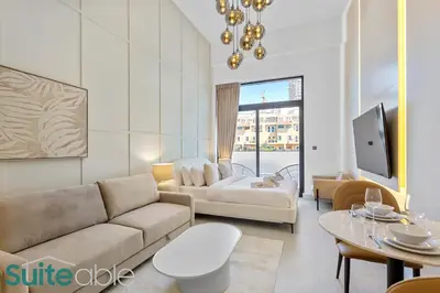 a living room with a couch and a tv at Luxe Interior Studio in Pantheon Elysee 3 in JVC in Dubai