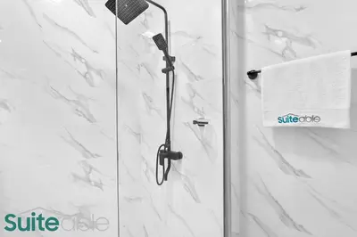 a shower with a glass door in a bathroom at Luxe Interior Studio in Pantheon Elysee 3 in JVC in Dubai