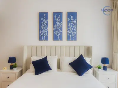 a bedroom with a bed with blue and white pillows at Relaxing Beach Escape in JBR in Dubai