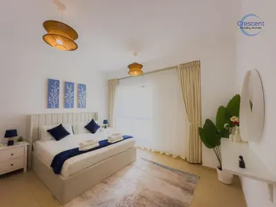 a bedroom with a large bed and a mirror at Relaxing Beach Escape in JBR in Dubai