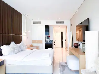 a bedroom with a large white bed in a room at Luxury Studio in Business Bay with Canal View in Dubai