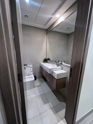 a bathroom with two sinks and a toilet at Studios Apartment in Azizi Riviera in Dubai