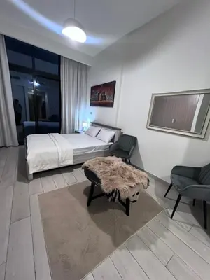 a bedroom with a bed and a table and chairs at Studios Apartment in Azizi Riviera in Dubai