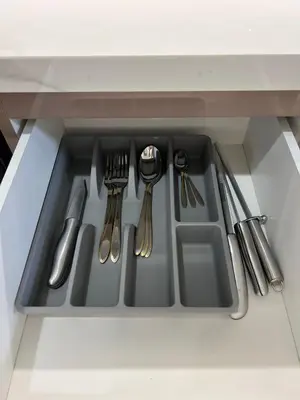 a kitchen sink with silver utensils in a drawer at Studios Apartment in Azizi Riviera in Dubai