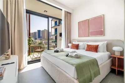 a bedroom with a large bed and a large window at Exquisitely designed studio in Oxford terraces JVC in Dubai