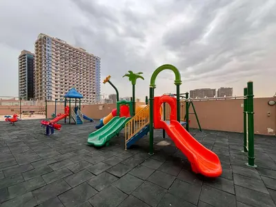 a playground with colorful slides and swings at Frank Porter - Lago Vista in Dubai