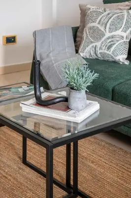 a glass coffee table with books and a plant on it at Frank Porter - Lago Vista in Dubai
