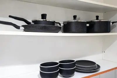a kitchen with pots and pans on a shelf at Stylish JLT Studio Lakeview Metro 5min & Marin in Dubai