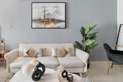 a living room with a couch and a painting on the wall at Stylish JLT Studio Lakeview Metro 5min & Marin in Dubai