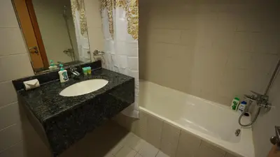 a bathroom with a sink and a bath tub at 1BHK full canal view apartment in Business bay ! in Dubai