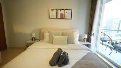 a bedroom with a large bed with a large window at 1BHK full canal view apartment in Business bay ! in Dubai
