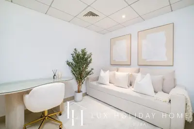 a living room with a white couch and a desk at LUX The Burj Khalifa Fountain View Suite 2 in Dubai