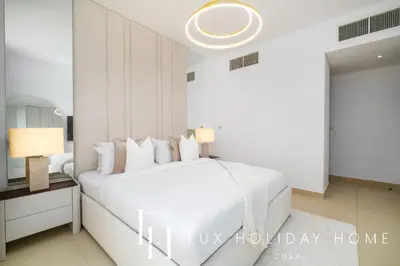 a white bedroom with a white bed and a mirror at LUX The Burj Khalifa Fountain View Suite 2 in Dubai