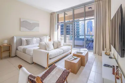 a living room with a couch and a tv at Frank Porter - Bay Square in Dubai
