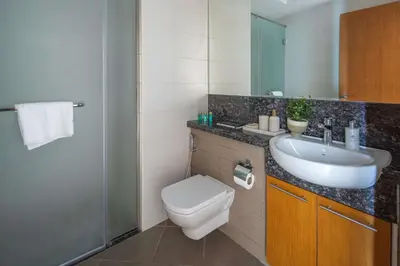 a bathroom with a sink and a toilet and a mirror at Frank Porter - Bay Square in Dubai
