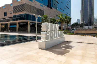 a sign that says buy sau in front of a building at Frank Porter - Bay Square in Dubai
