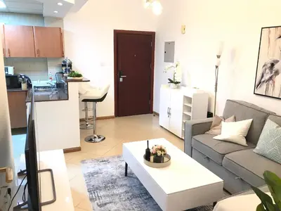 a living room with a couch and a coffee table at Cozy one bedroom close to beach and metro station in Dubai
