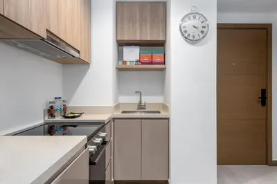 a kitchen with a sink and a clock on a wall at Missoni Luxury Life Suite DPA Direct Pool Access in Dubai