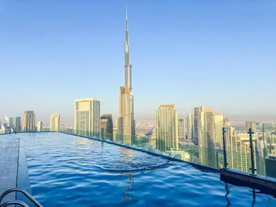 a infinity pool with a city skyline in the background at New Luxury SeaView 2Bed - Spectacular Rooftop Infinity Pool, Bar & Burj Views! in Dubai