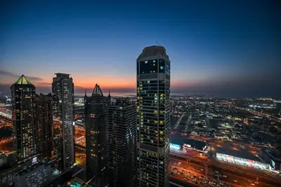 a view of a city skyline at night at New Luxury SeaView 2Bed - Spectacular Rooftop Infinity Pool, Bar & Burj Views! in Dubai