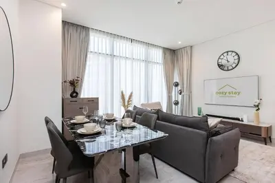a living room with a table and chairs and a couch at High-Rise 1BR Apartment with Burj Khalifa view in Dubai