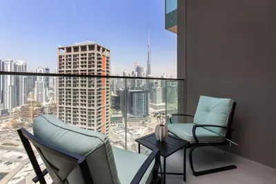 a balcony with two chairs and a table with a view at High-Rise 1BR Apartment with Burj Khalifa view in Dubai