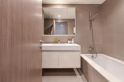 a bathroom with a white sink and a bath tub at ALiving Elite 3BR Apartment I Burj Khalifa & Fountain View I Burj Royale in Dubai