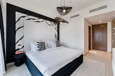 a bedroom with a bed with a black and white headboard at ALiving Elite 3BR Apartment I Burj Khalifa & Fountain View I Burj Royale in Dubai