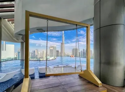 a swing in a room with a view of the city at Stylish 2BR Apt in 5 Star Hotel with Burj Khalifa Views in Dubai