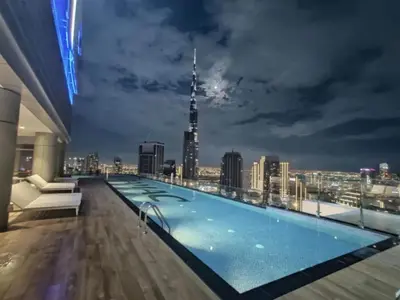 a swimming pool on the roof of a building with a city skyline at Stylish 2BR Apt in 5 Star Hotel with Burj Khalifa Views in Dubai