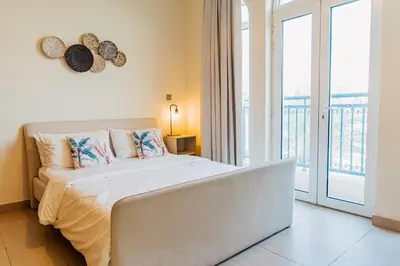 a bedroom with a bed and a balcony at Stunning 4BR Jumeira Park Villa With Pool and Jacuzzi in Dubai