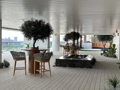 a room with tables and chairs with trees in it at Trophy-Lux 1BR Jacuzzi Suite Busbay W Big Balcony in Dubai