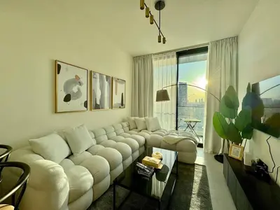 a living room with a white couch and a large window at Stylish 1br With Garden View In Jvc in Dubai