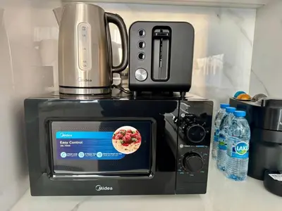 a food processor sitting on top of a microwave at Stylish 1br With Garden View In Jvc in Dubai