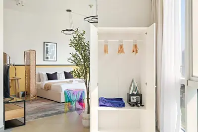 a white bedroom with a bed and a window at Silkhaus Chic Studio at Barsha Heights in Madison in Dubai