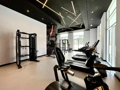 a gym with treadmills and ellipticals in a room at Silkhaus Cozy Studio at Madison in Barsha Heights in Dubai