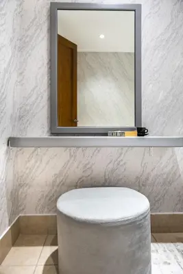 a mirror above a stool in a bathroom at Stylish 2-Bedroom in the Heart of OldTown Dubai in Dubai