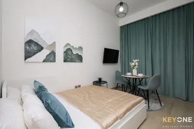 a bedroom with a bed and a table in it at Modern Elegance Studio in Azizi Riviera in Dubai
