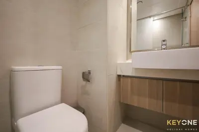 a bathroom with a white toilet and a sink at Modern Elegance Studio in Azizi Riviera in Dubai