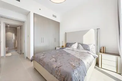 a bedroom with a large bed and a bathroom at Forte Tower 1 in Dubai